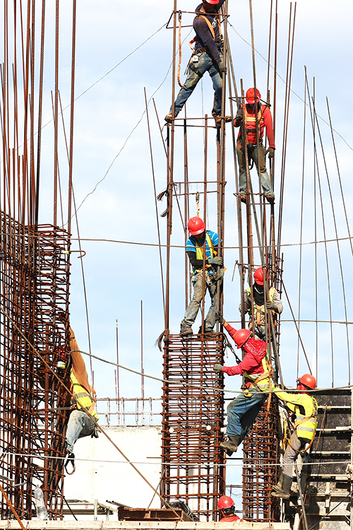 Image of a construction site and workers working hard